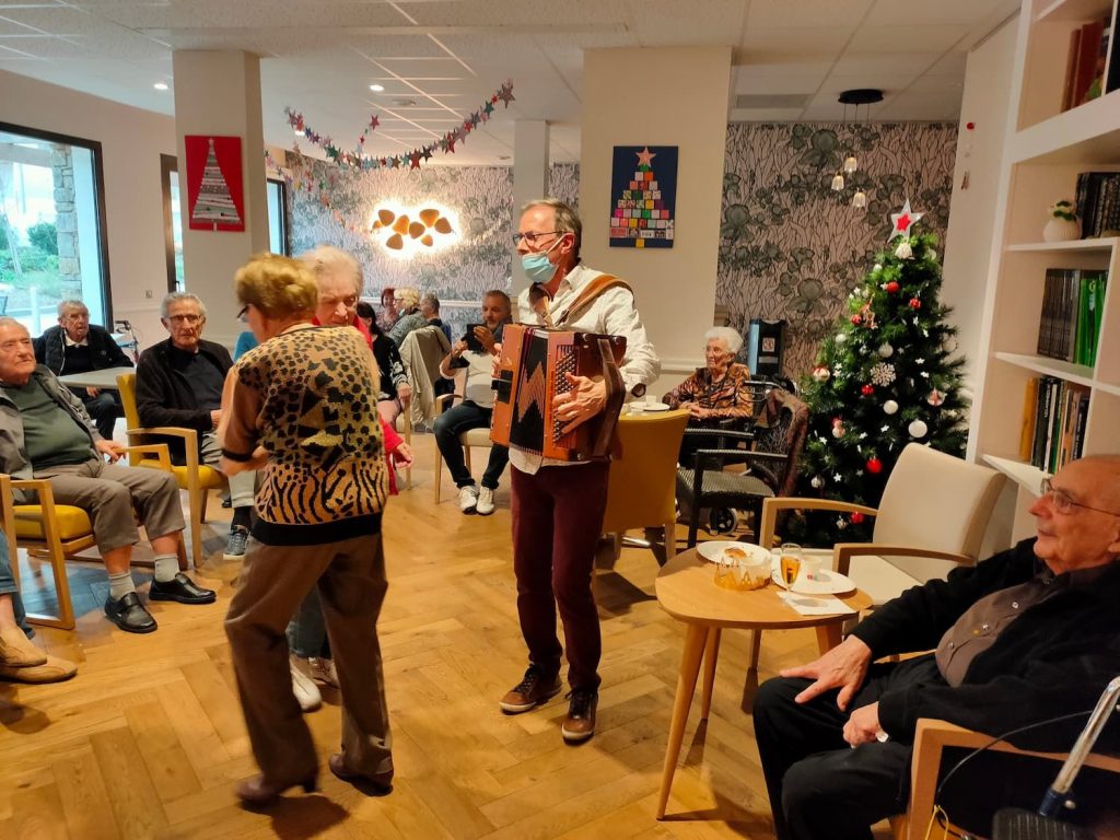 Joueur d'accordéon et résidents qui dansent